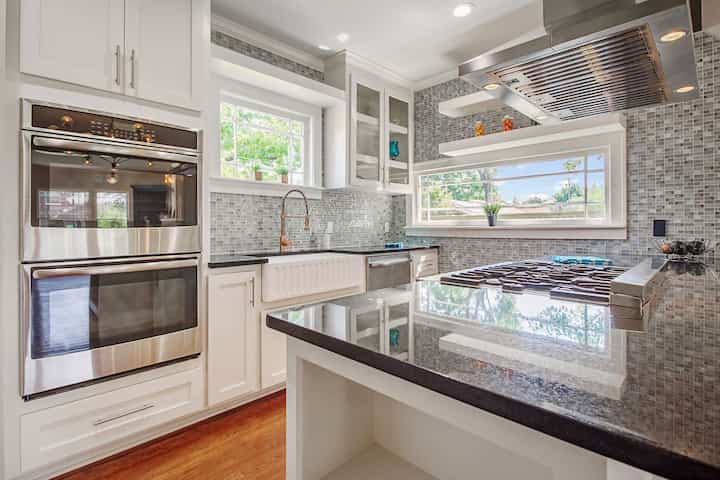 An image of a modern kitchen with sleek appliances, featuring a gas stove, refrigerator, and built-in microwave in Spring